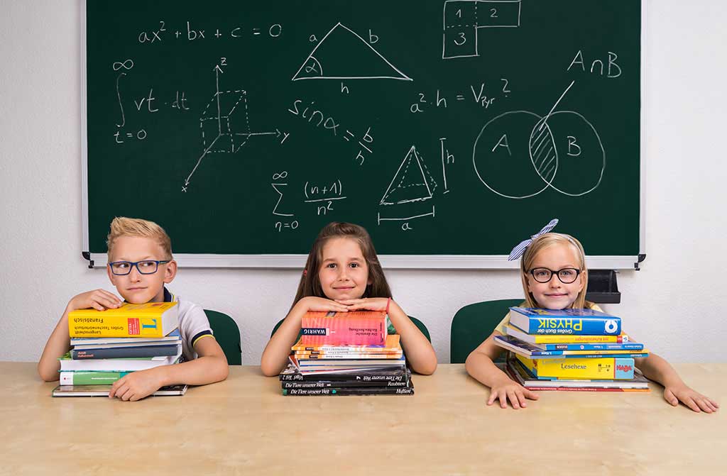 ko-kids-kinder-schule-bank-buecher-lernen-nachhilfe-tafel-grinsen-positiv